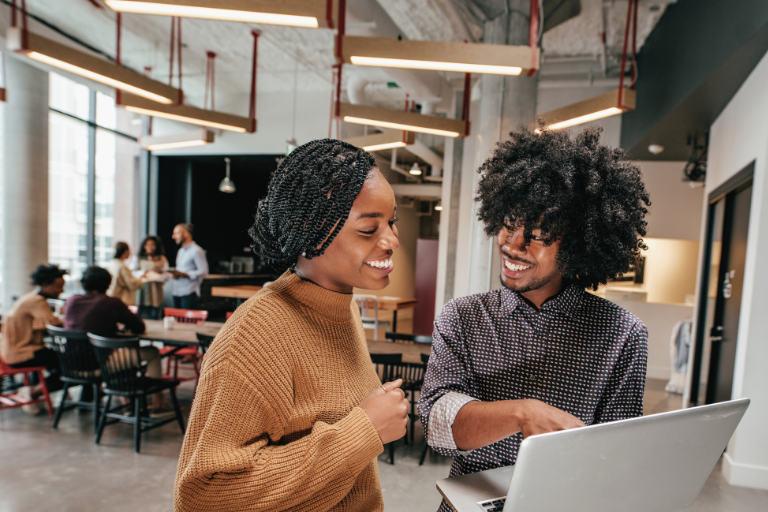 Young people working on laptops together in a coworking space